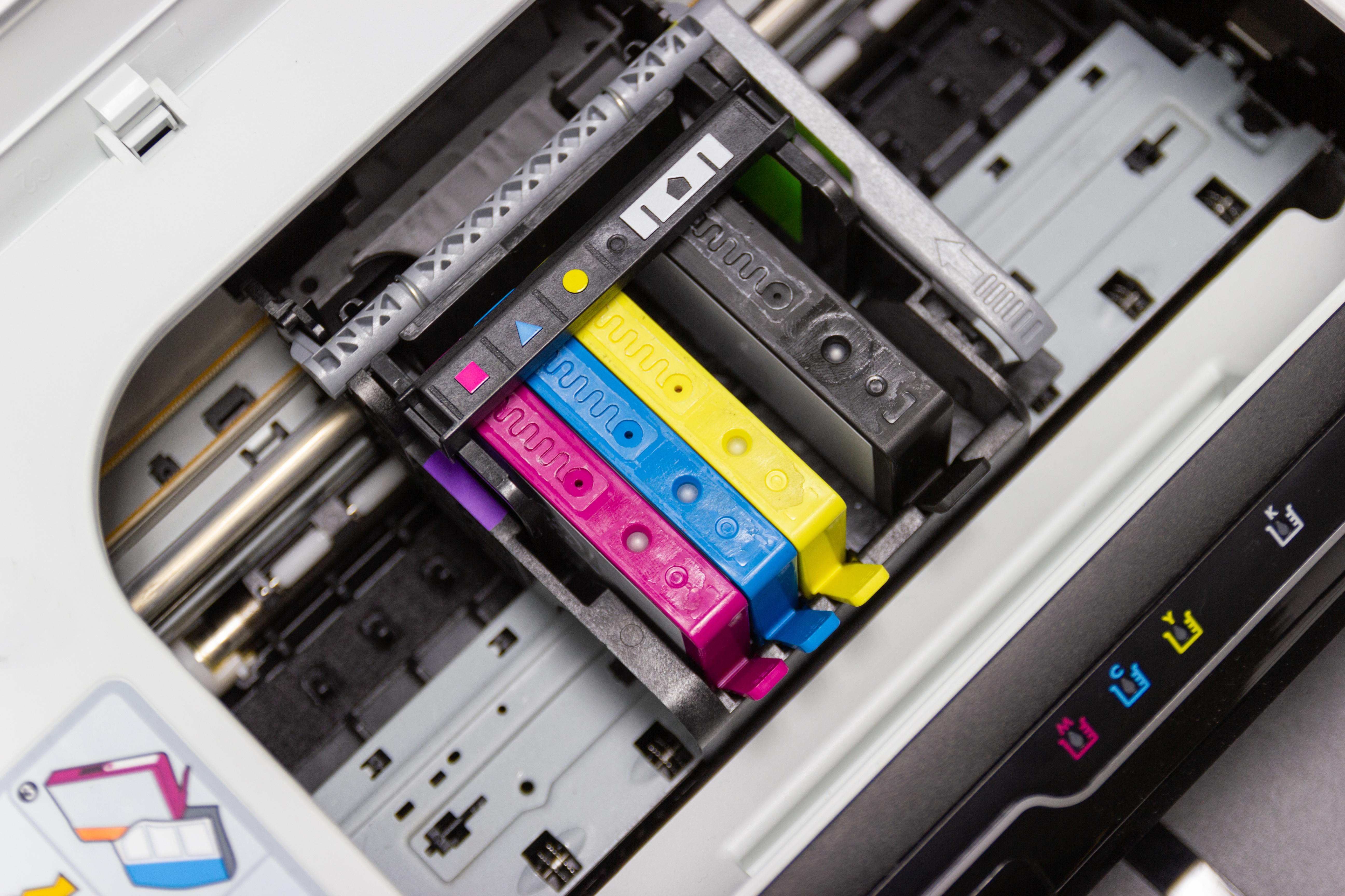 Close-up of CMYK ink cartridges inside a printer