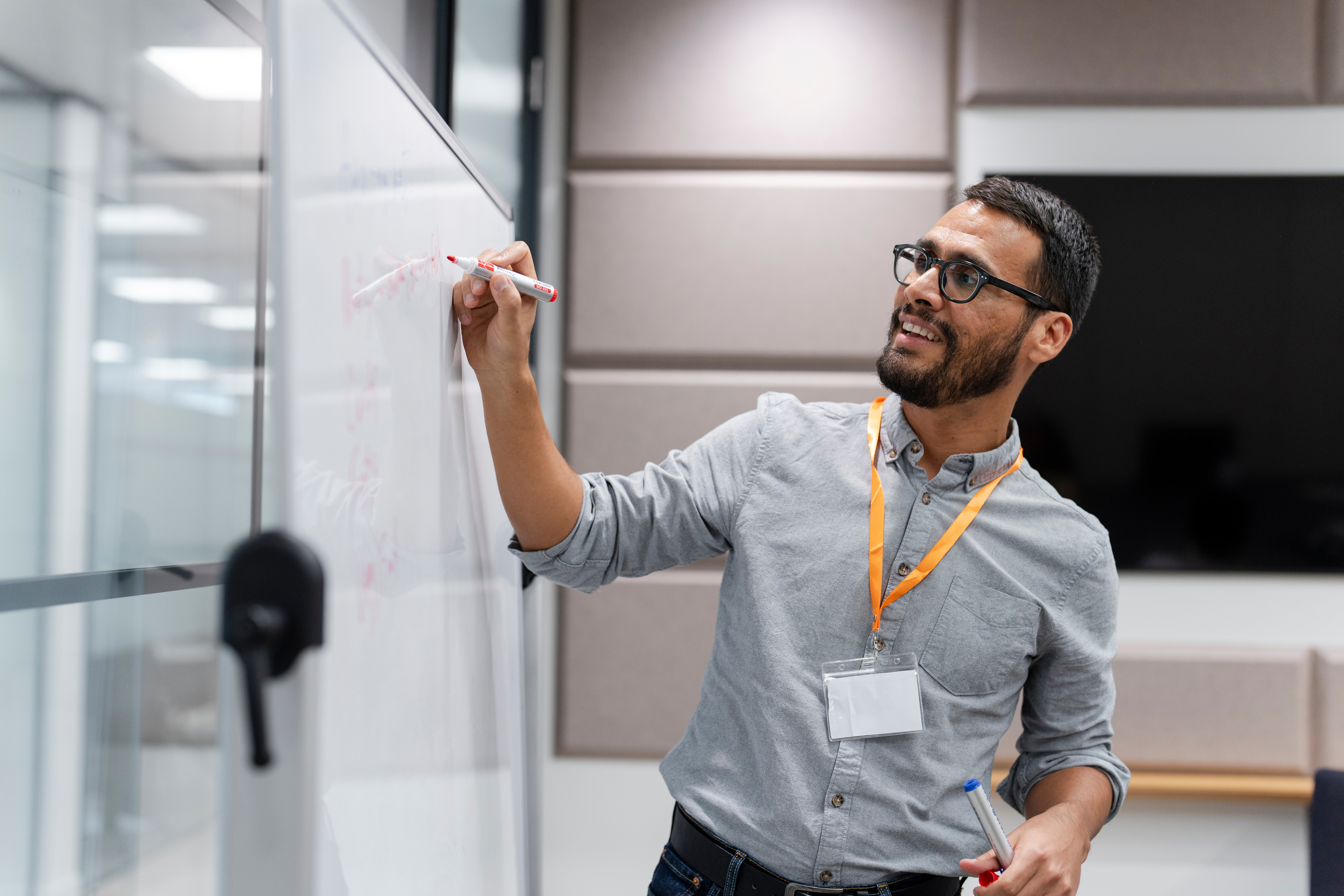 Presenter writing on a whiteboard during a workshop